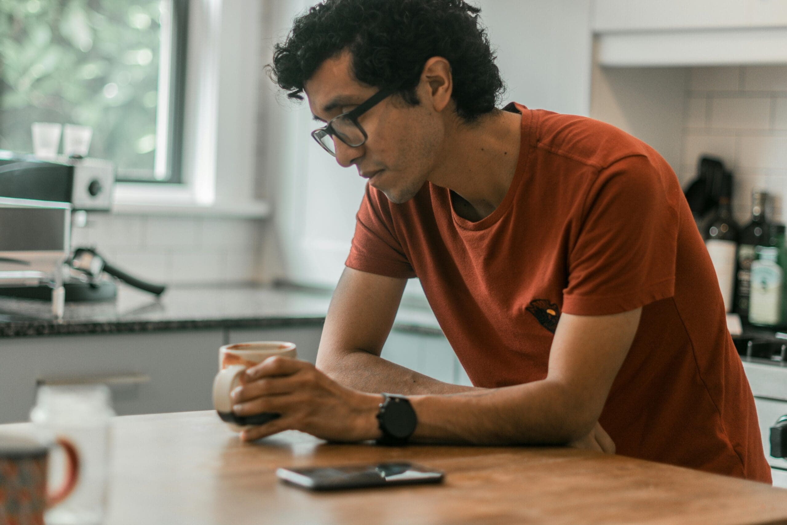 Man sitting with coffee, reflecting on anxious thoughts and the anxiety cycle
