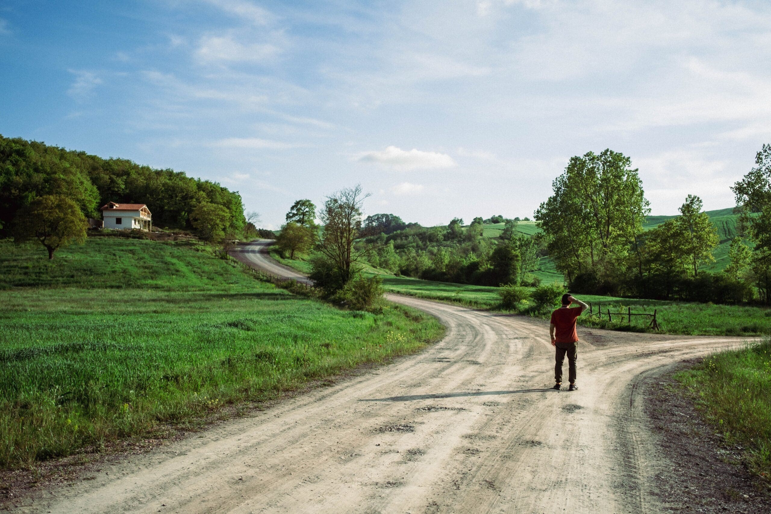 person standing at a crossroads in the countryside, managing anxiety and life transitions
