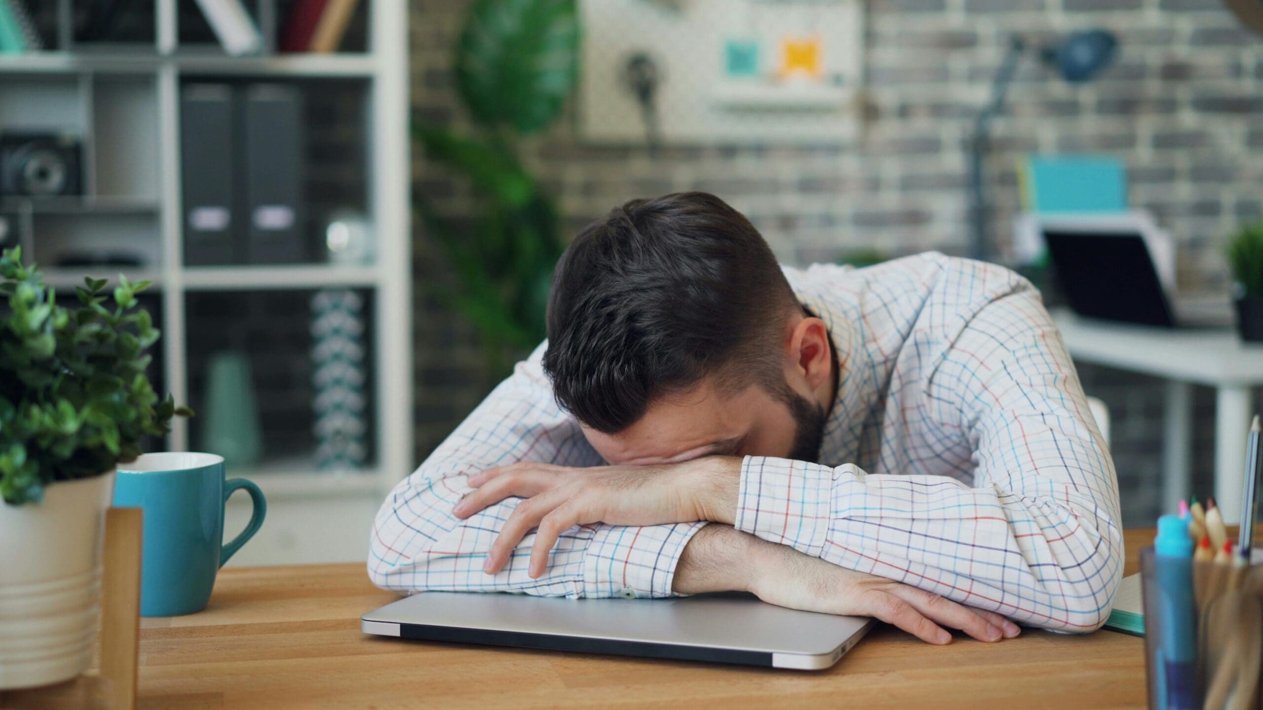 A man sitting at his office desk looking like burnout and overwhelmed